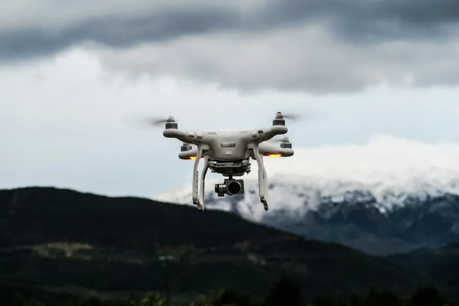 White DJI Phantom quadcopter with a gimbal camera in flight